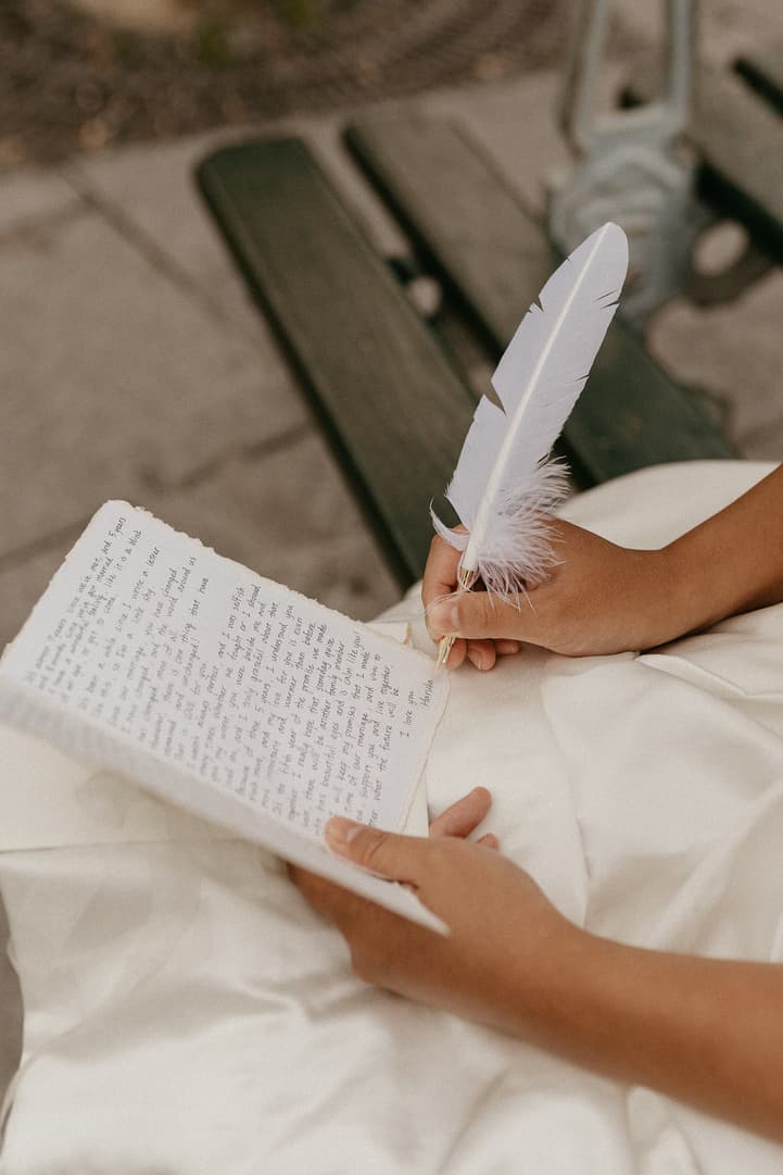 Haruka writing her vows in a notebook with a feather pen