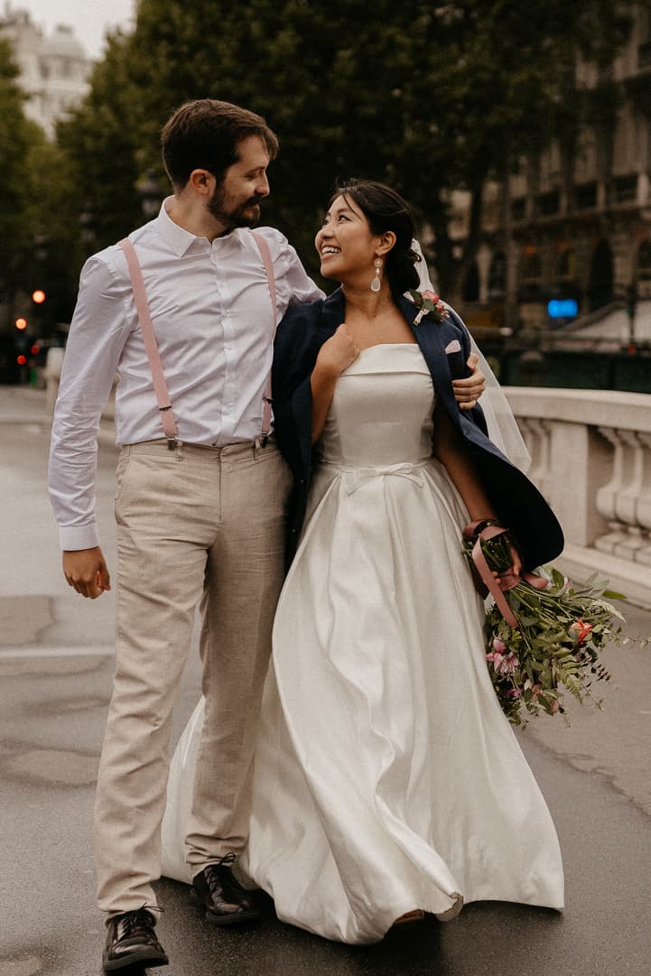 Haruka and Florent laughing together on a bridge over the Seine