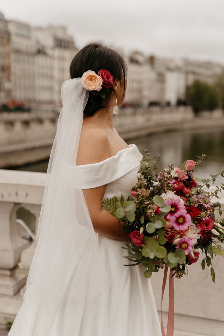 Haruka from behind, a flower in her hair and her bouquet in her hand, by the Seine