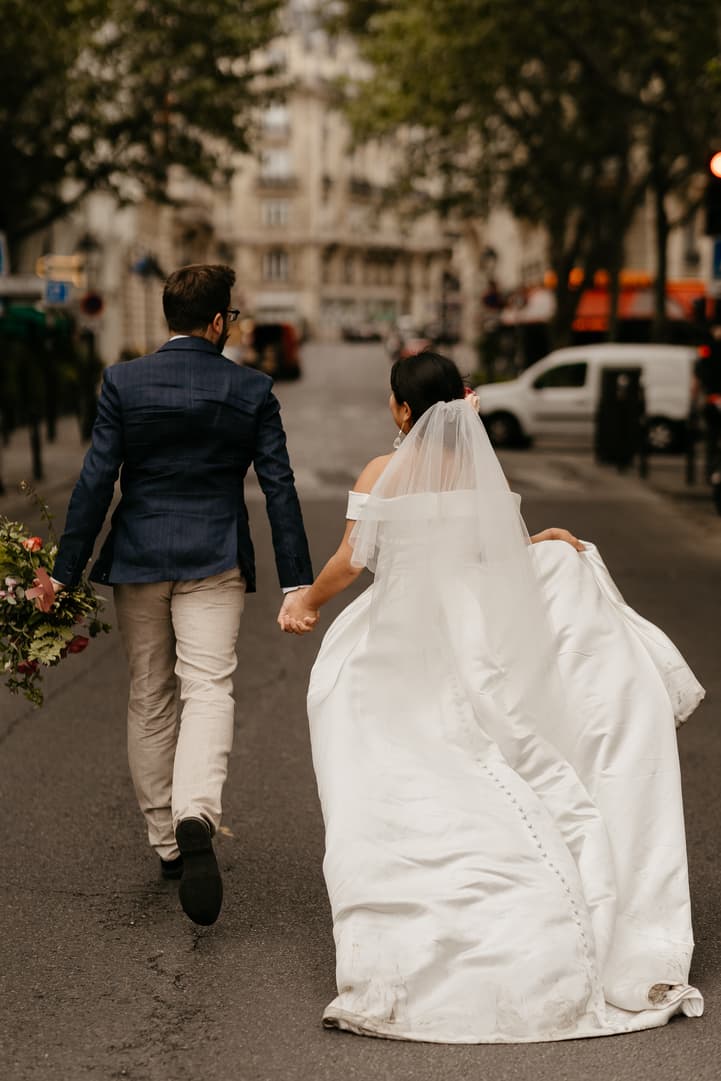 Haruka and Florent walking away hand in hand down a Paris street