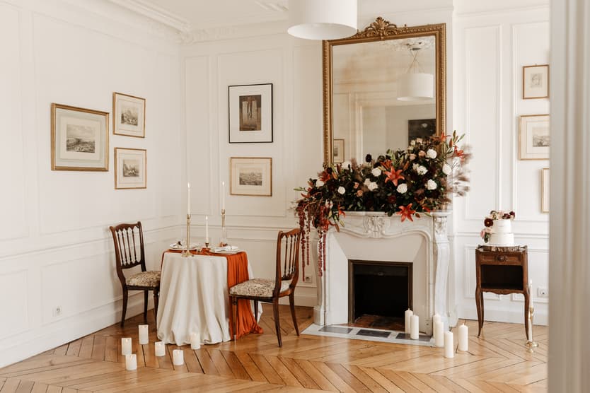 Elegant Paris salon with a floral fireplace, set table, chairs and candles in soft light