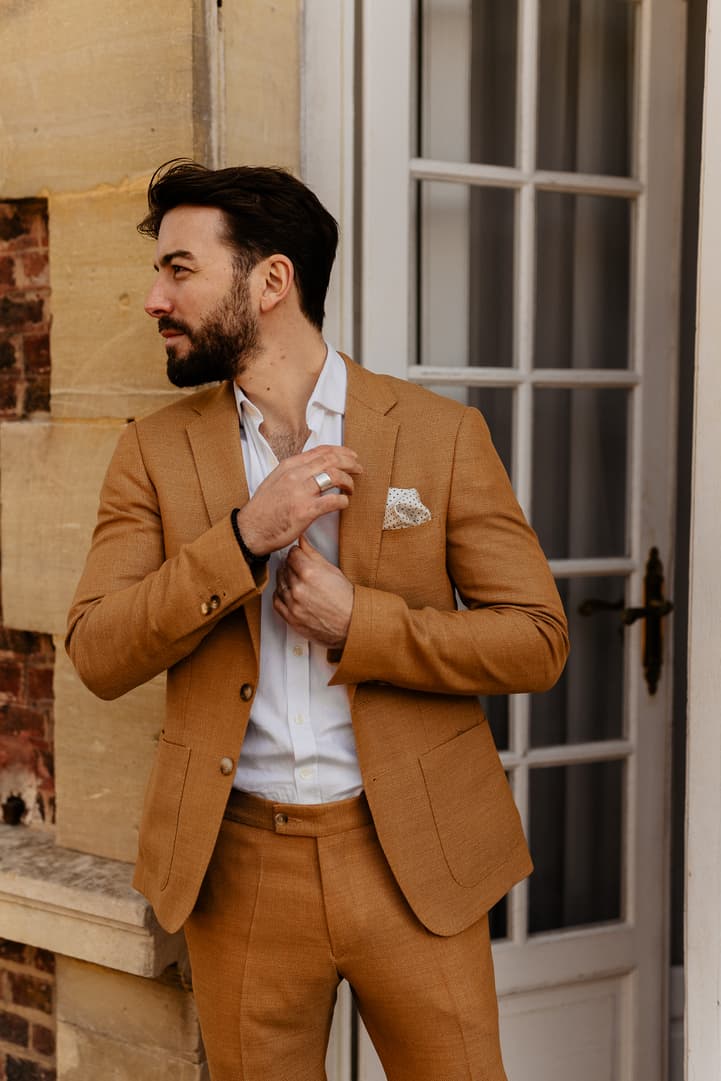 Groom preparation moment in orange suit