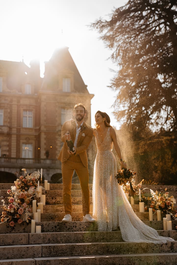 groom and bride celebrate with champagne popping