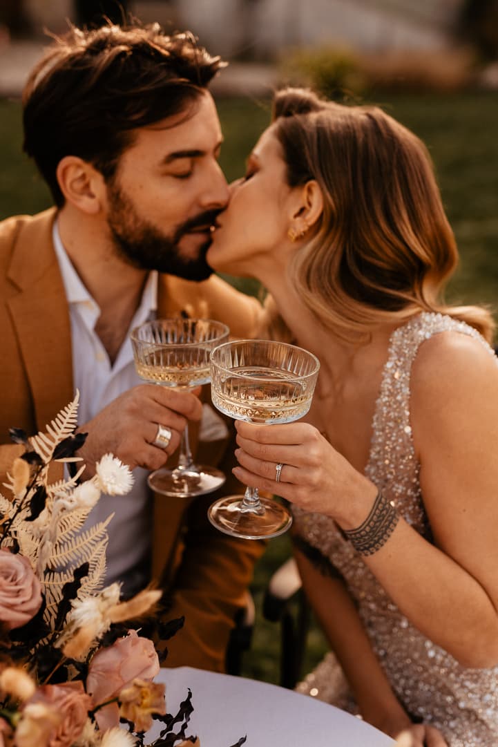 groom and bride kiss and celebration with cake and champagne