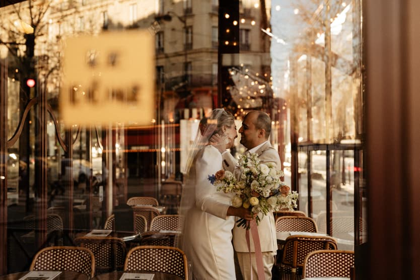 Paris Elopement Packages Elopement Photographer Videographer winter elopement couple laughing through the glass cafè Paris 