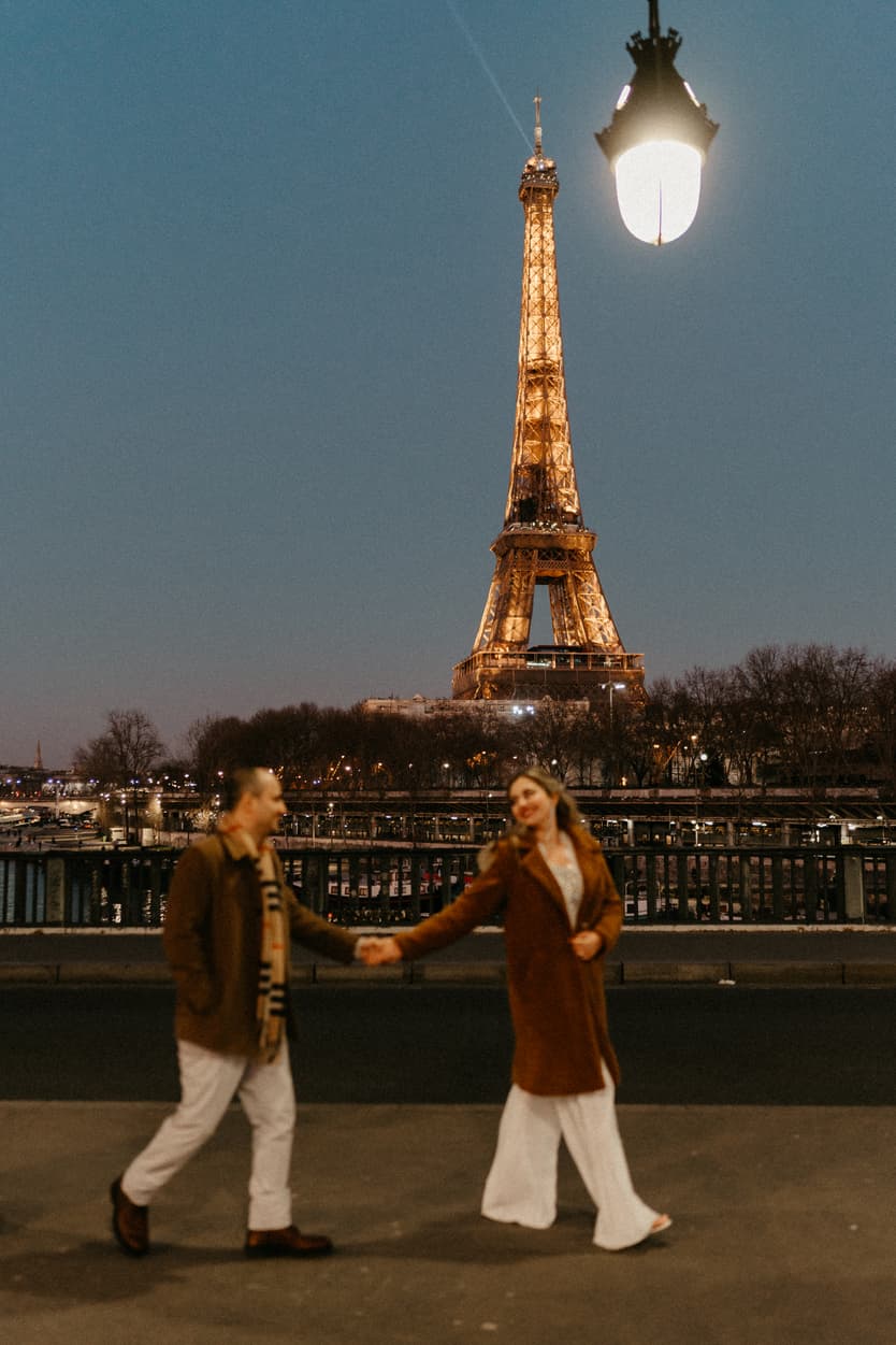 Paris Elopement Packages Elopement Photographer Videographer winter elopement couple walking Eiffel Tower view Bir Hakeim