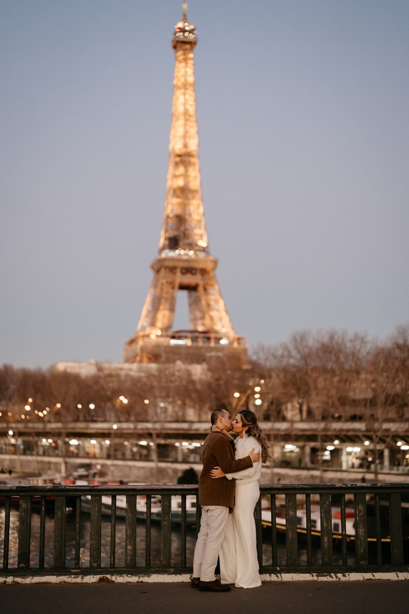 Paris Elopement Packages Elopement Photographer Videographer winter elopement couple kissing Eiffel Tower view Bir Hakeim