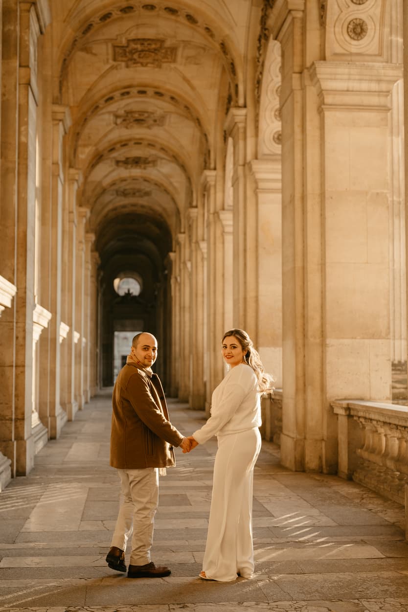 Paris Elopement Packages Elopement Photographer Videographer winter elopement couple walking hallway Louvre Paris 