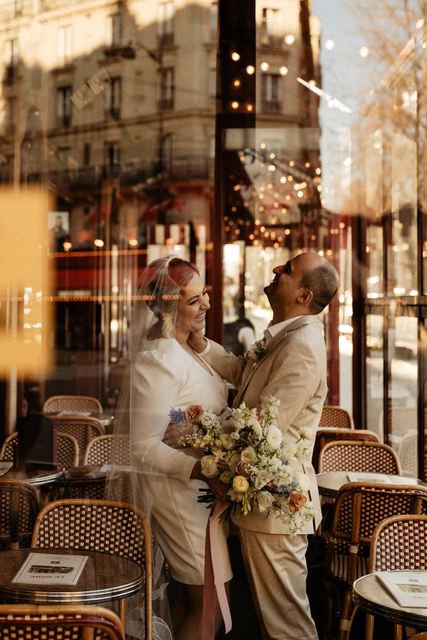 Paris Elopement Packages Elopement Photographer Videographer winter elopement couple laughing through the glass cafè Paris 
