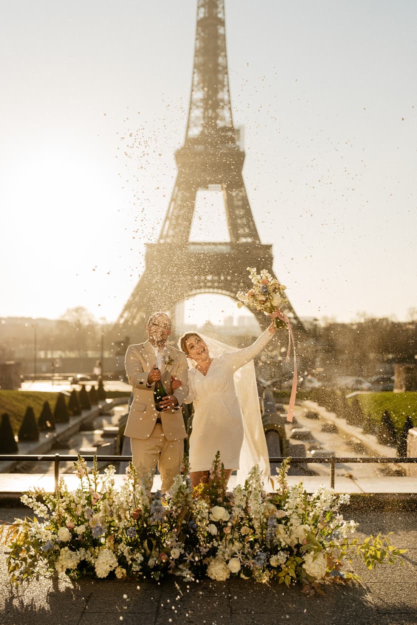 Paris Elopement Packages Elopement Photographer Videographer winter elopement couple ceremony flower decoration Eiffel Tower view chamoagne pop