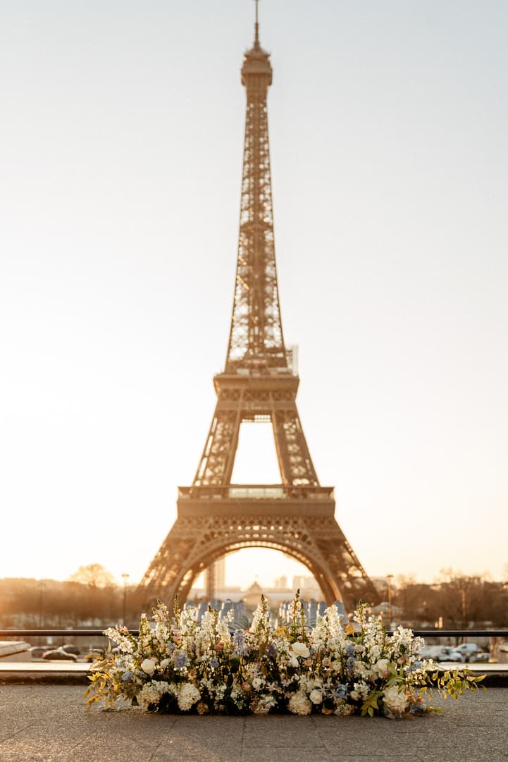 Sunlit floral arrangement before the Eiffel Tower at golden hour on a Paris terrace