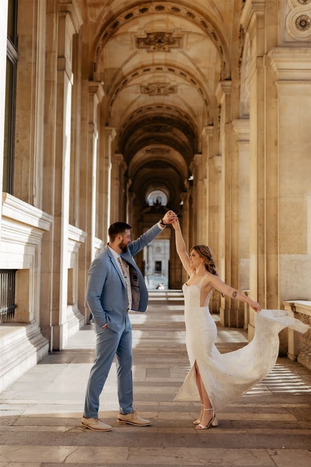 Bride and groom dance beneath a grand Paris colonnade in warm light