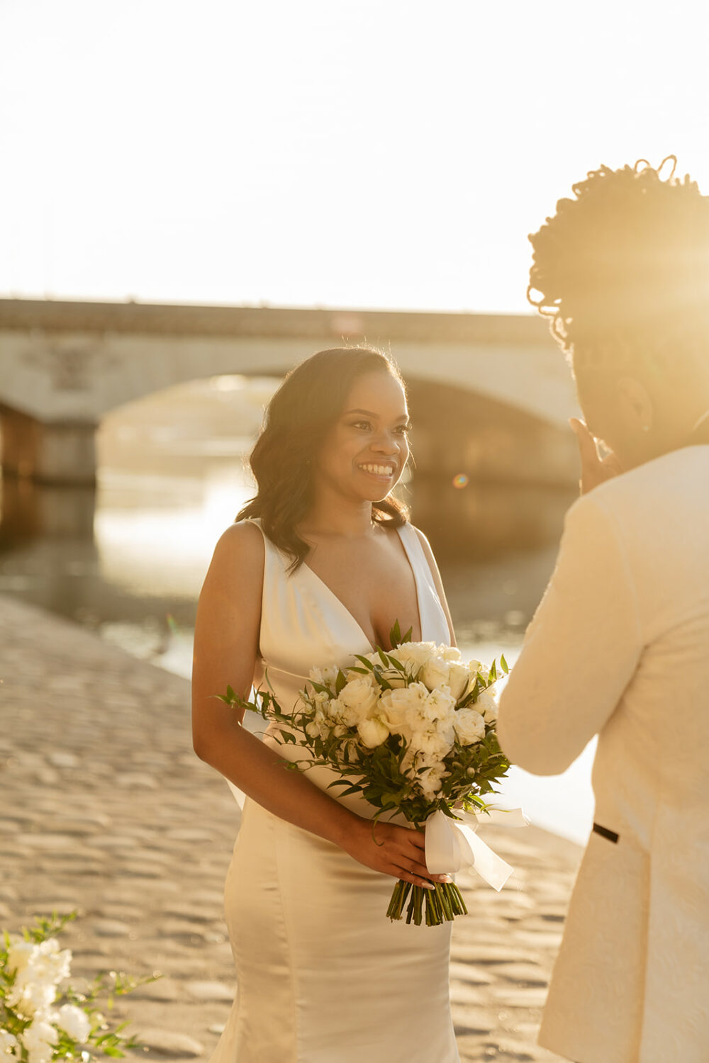 paris elopement first look by the Seine river sunrise officiant white flower
