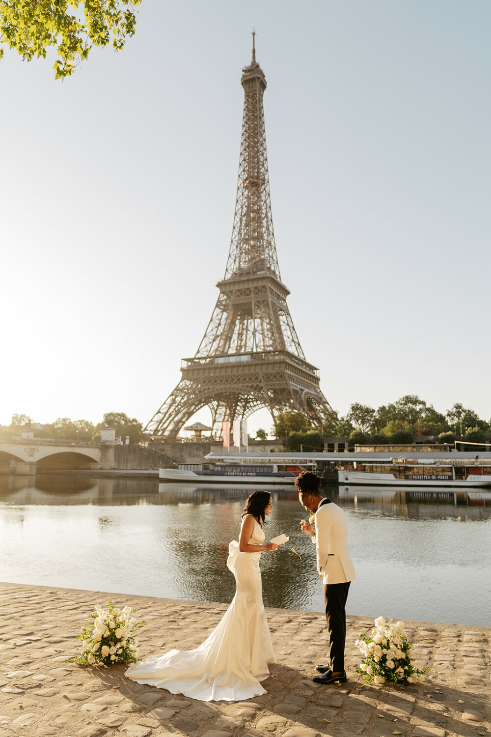 couple exchanging vows Paris elopement Eiffel tower by the seine with white folowerr wedding decoration 
