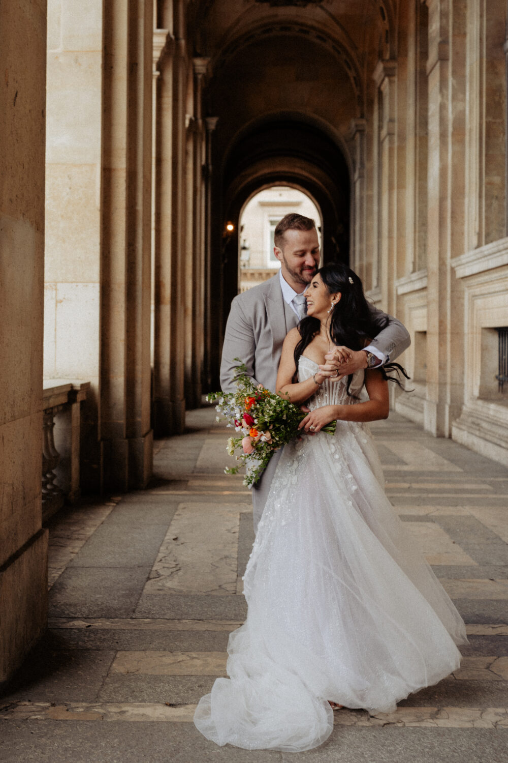 Groom hug bride from the back spring bouquet Louvre