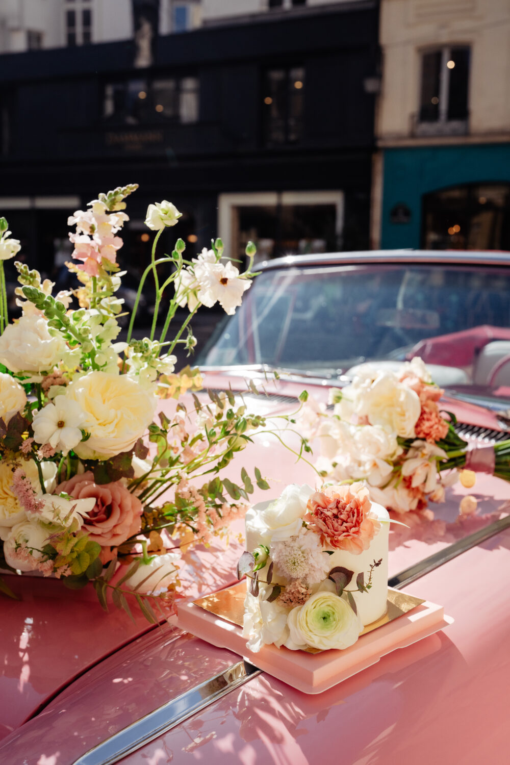 Pink vintage elopement car in Paris with a cake and bouquet