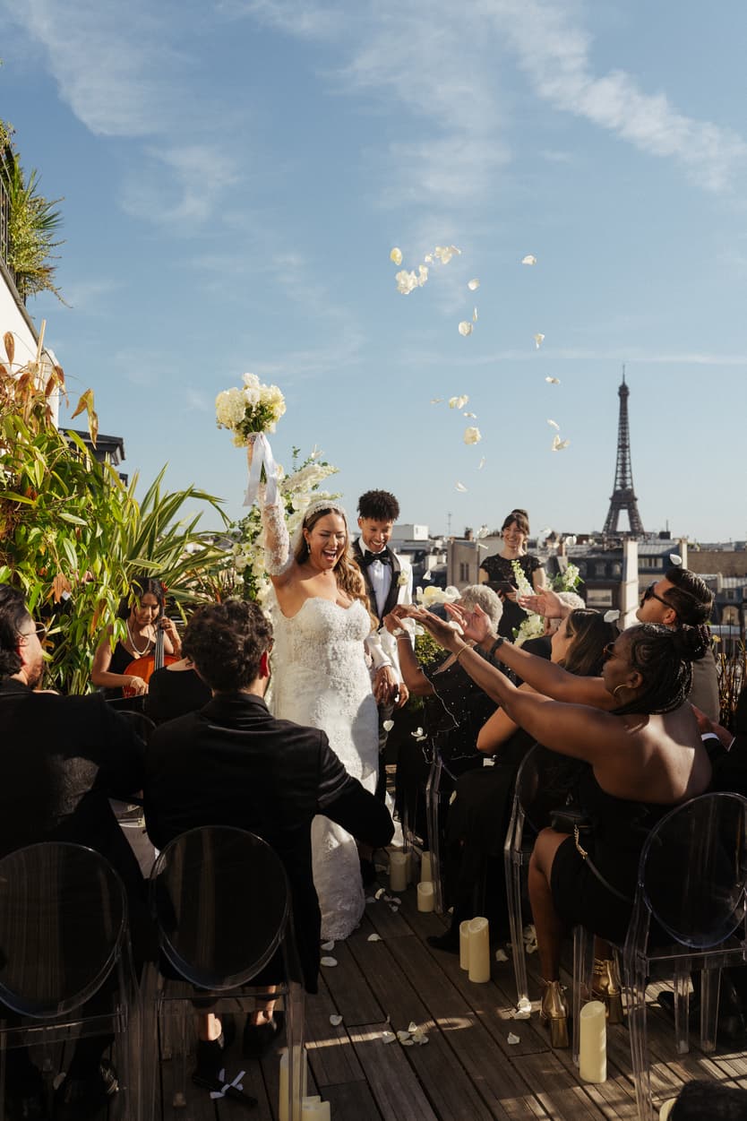Guests throwing petals over the newlyweds on a Paris rooftop terrace