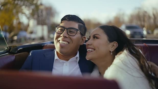 Cindy and Ed laughing in a convertible in Paris, a still from their video
