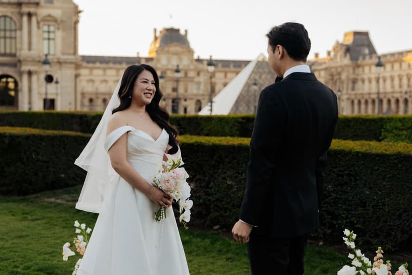 Nancy and Jason face to face in the garden in front of the Louvre, first look of their Paris elopement