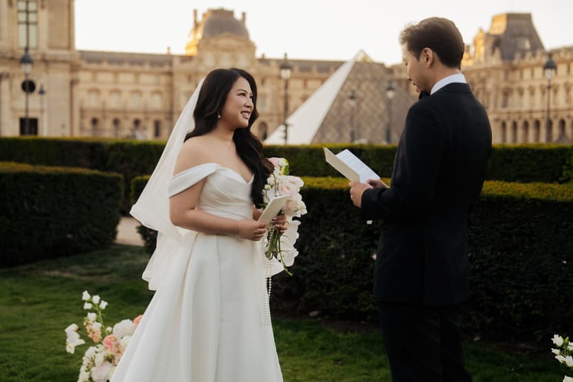 Jason reading his vows to Nancy in the garden in front of the Louvre and the glass pyramid