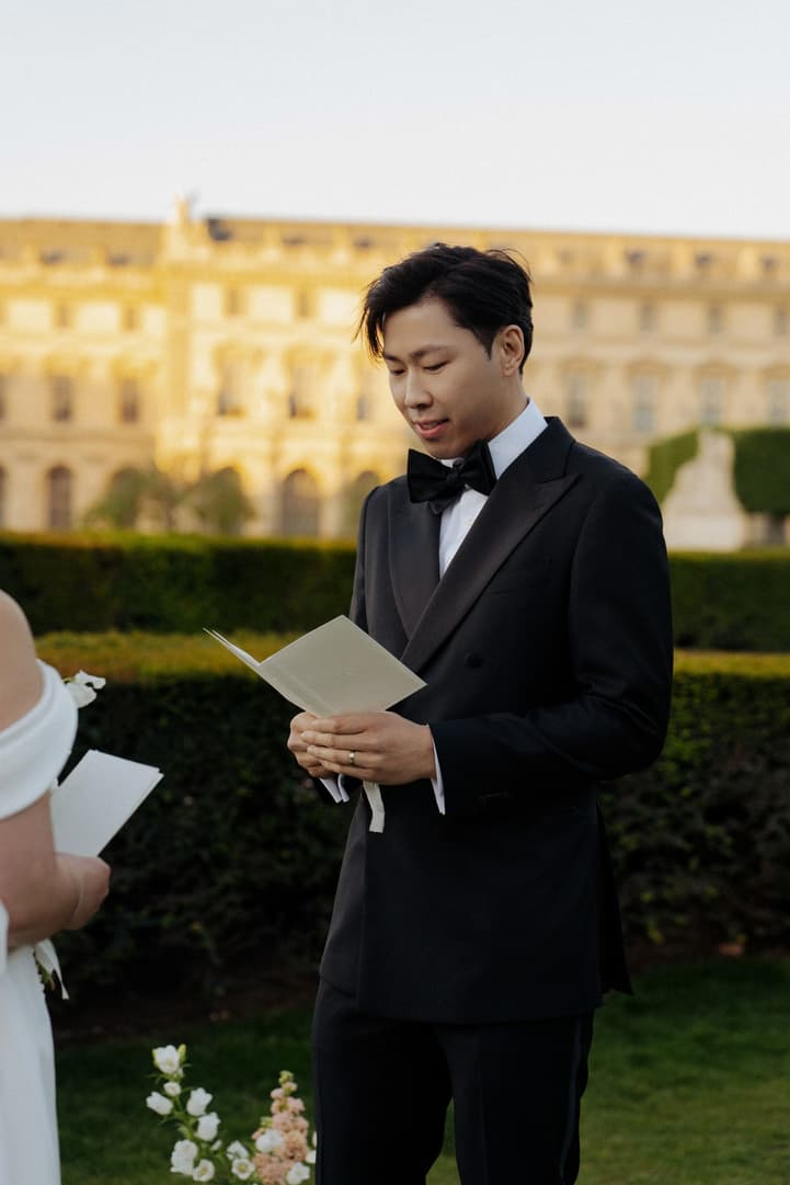 Jason reading his personal vows from a vow book at their Paris elopement ceremony