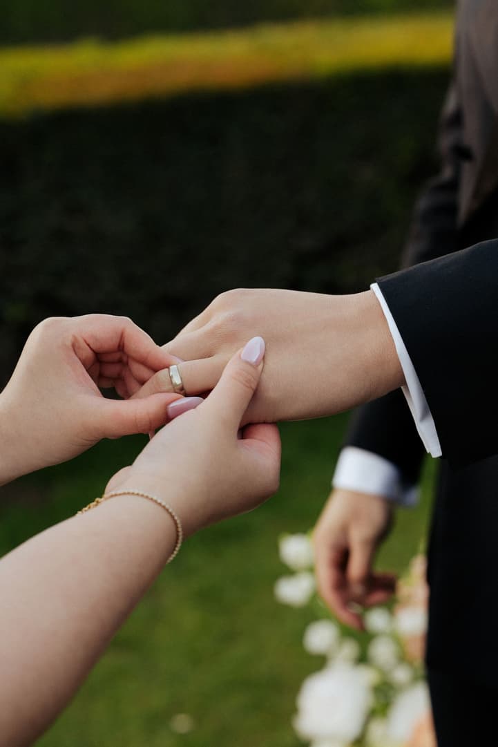 Nancy placing the wedding ring on Jason's finger