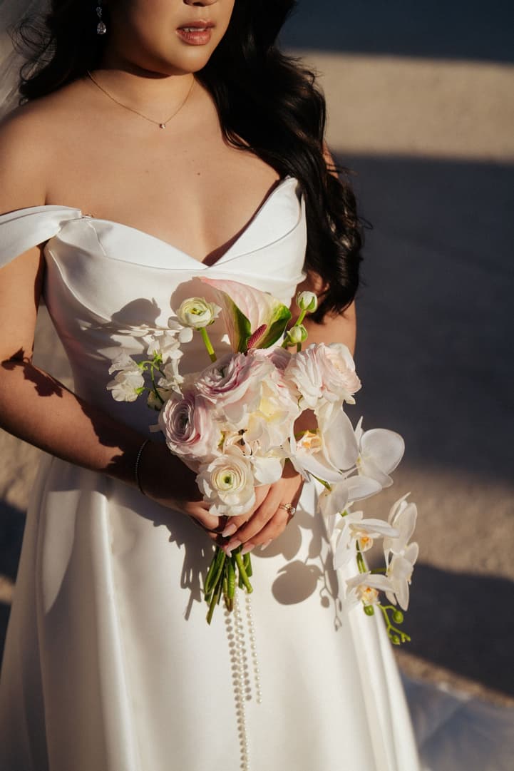 Nancy's bridal bouquet of pink and white roses, ranunculus and cascading white orchids with pearls