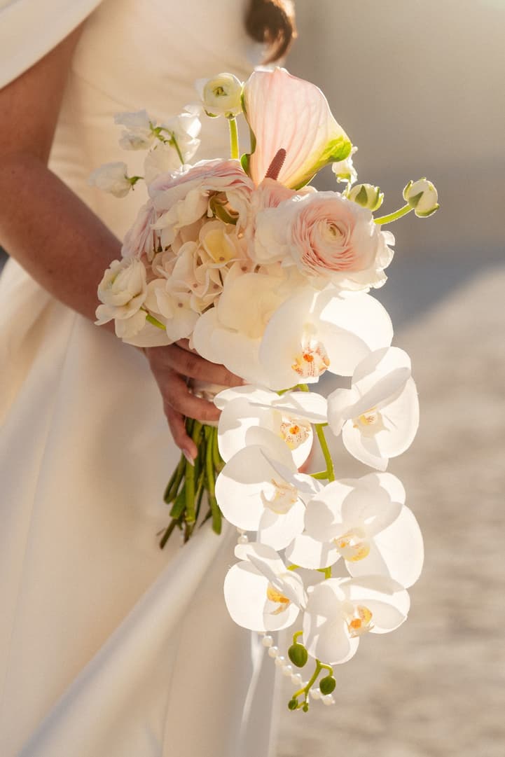 Detail of the cascading orchid bouquet against Nancy's wedding dress