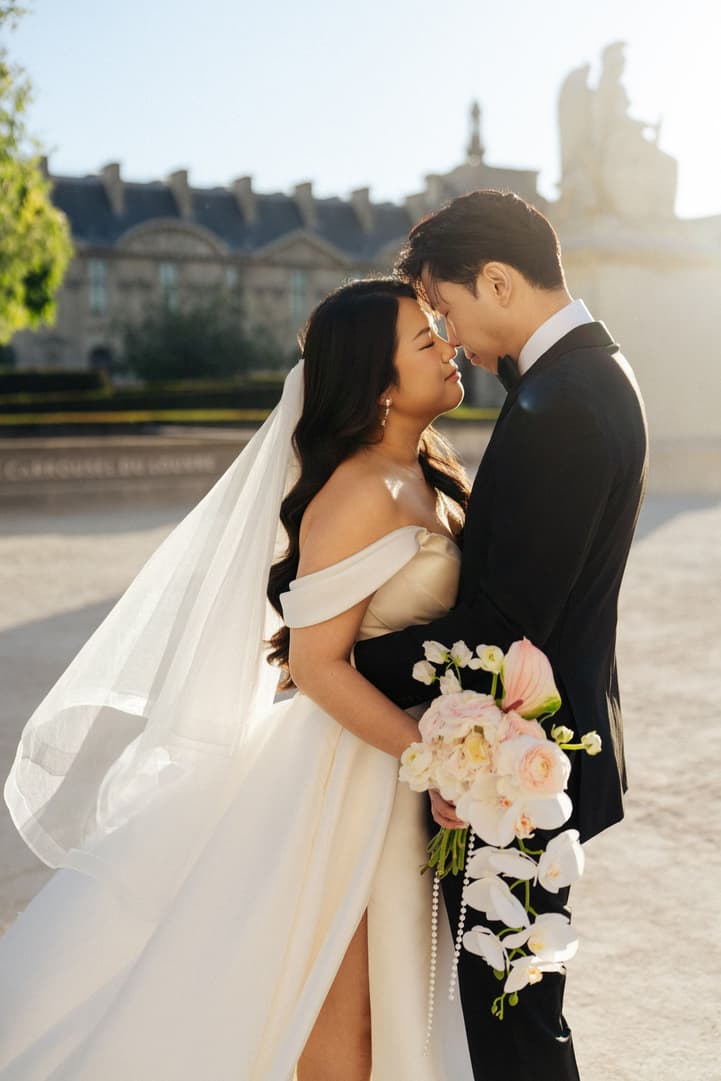 Nancy and Jason forehead to forehead in the courtyard of the Louvre