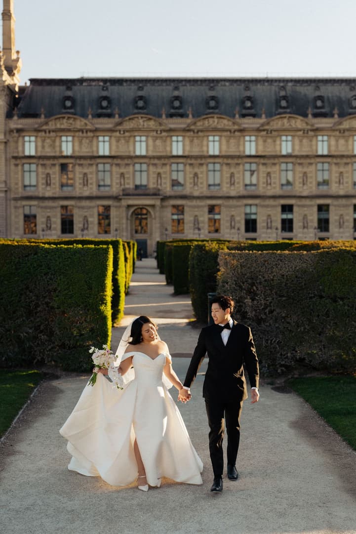 Nancy and Jason walking towards the camera between the hedges of the garden