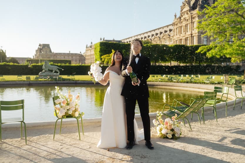 Nancy and Jason with champagne by the round basin of the Tuileries garden