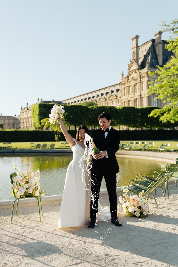 Champagne spraying as Nancy raises her bouquet by the Tuileries basin