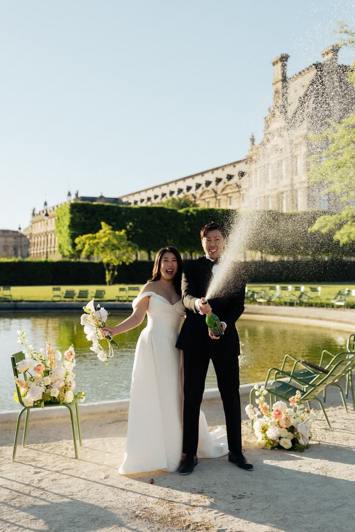 Jason spraying champagne by the Tuileries basin, Nancy cheering beside him