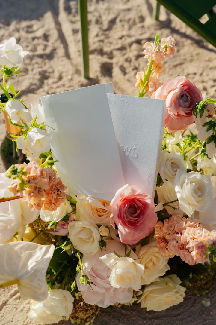 Their vow books, embossed with VOWS, tucked into the ceremony flowers