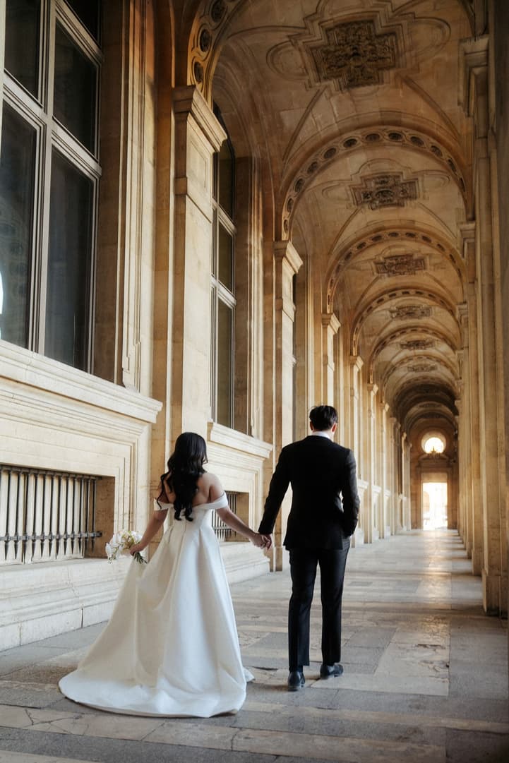 Nancy and Jason walking hand in hand in the hallway of the Louvre