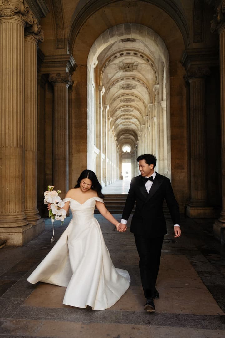 Nancy and Jason walking hand in hand down the hallway of the Louvre