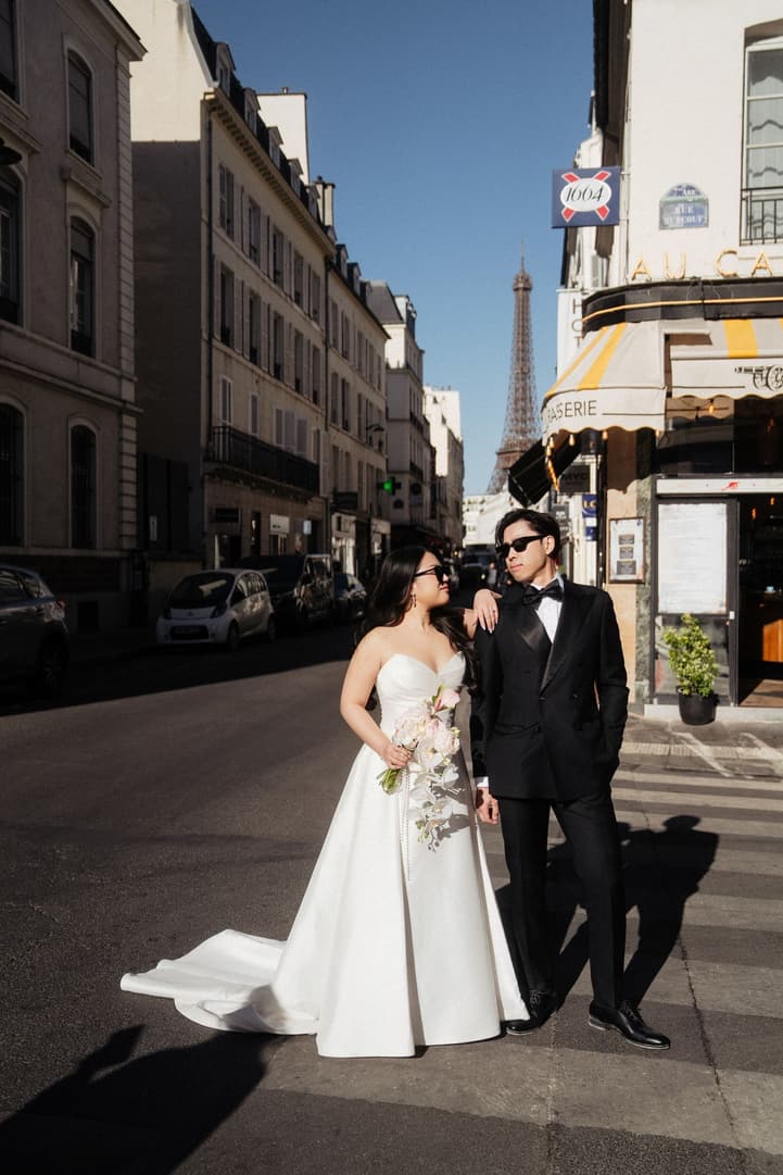 Nancy and Jason in sunglasses on a Paris street with the Eiffel Tower behind them