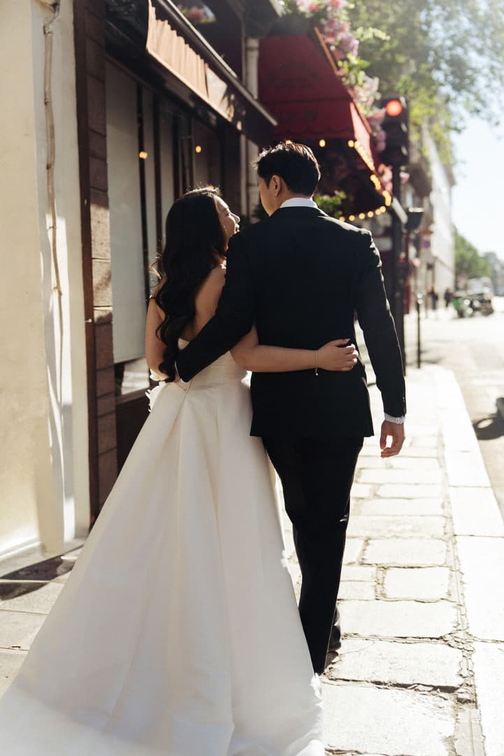 Nancy and Jason walking arm in arm along a Paris pavement