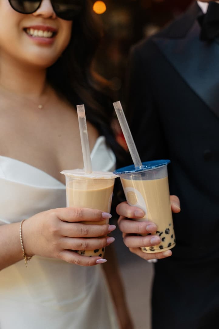 Nancy and Jason clinking their bubble teas on their elopement day in Paris