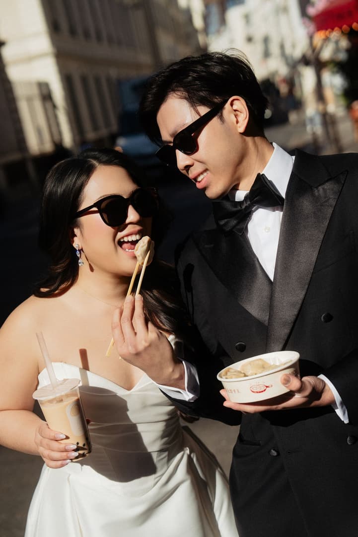 Jason watching Nancy eat a dumpling with chopsticks in a Paris street
