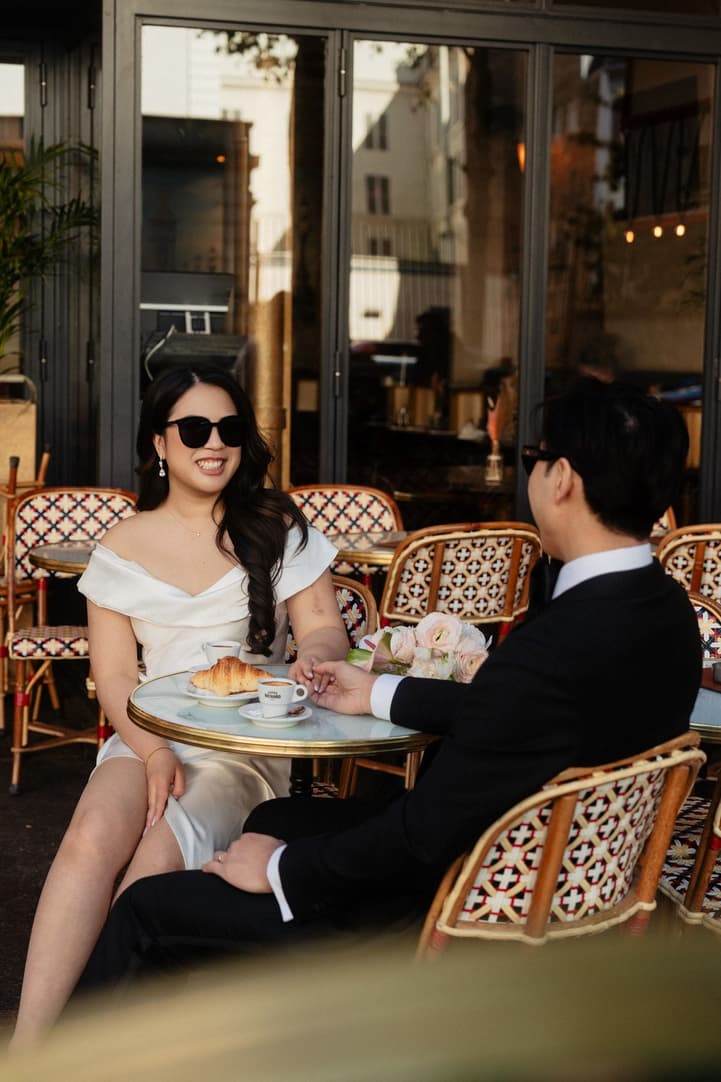Nancy and Jason at a café table with coffee and croissants