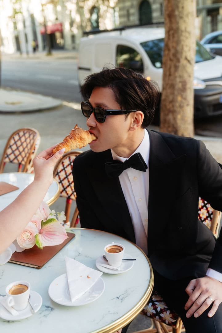Nancy feeding Jason a croissant at a Paris café