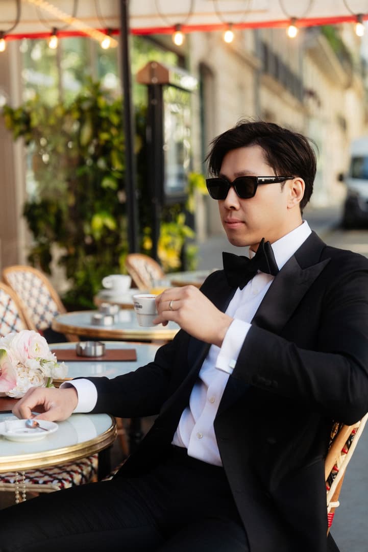 Jason in sunglasses eating a croissant at the café terrace