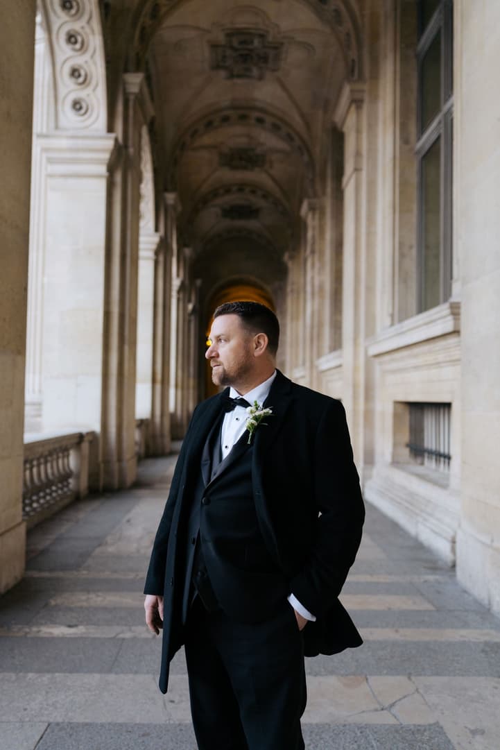 Michael waiting for Aphrodite in the hallway of the Louvre before their first look