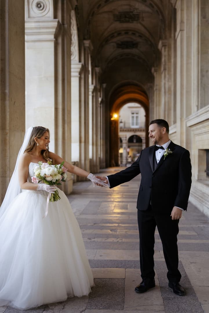 Michael turning to see Aphrodite in her wedding gown in the hallway of the Louvre