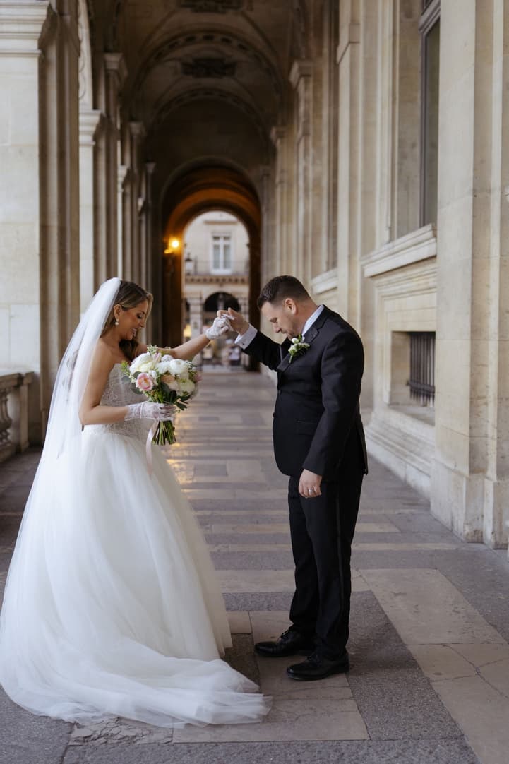 Michael bowing to kiss Aphrodite's hand in the hallway of the Louvre