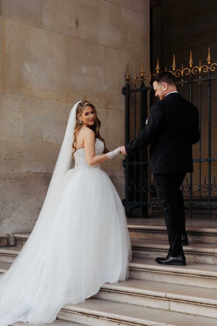 Michael leading Aphrodite up the steps of the Pavillon Denon