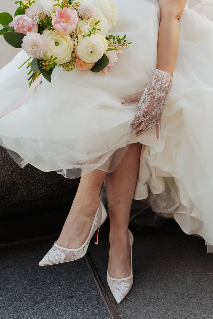 Aphrodite's lace bridal heels and bouquet under her ball gown