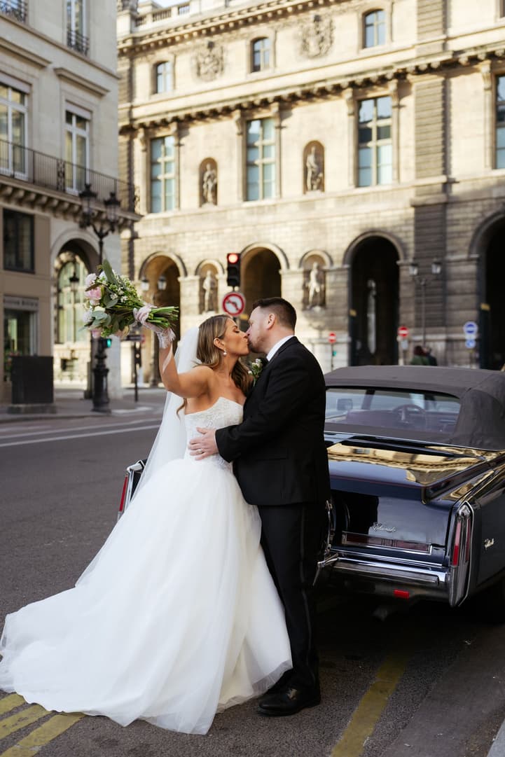 Aphrodite and Michael embracing beside their vintage car in Paris