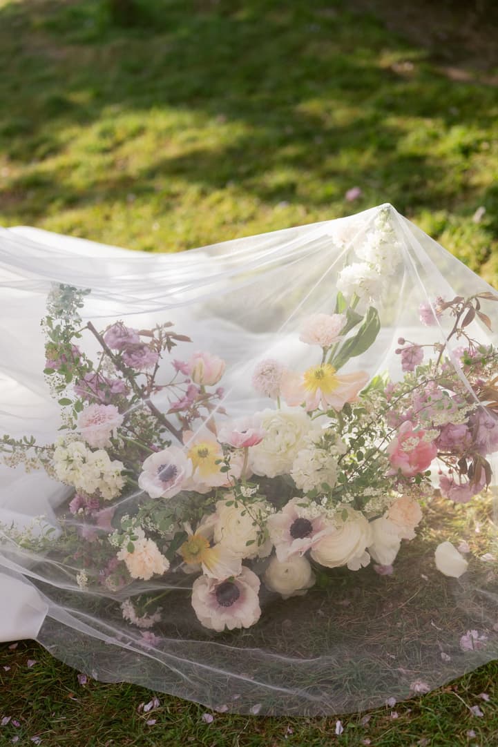 The ceremony flowers under Aphrodite's veil on the grass
